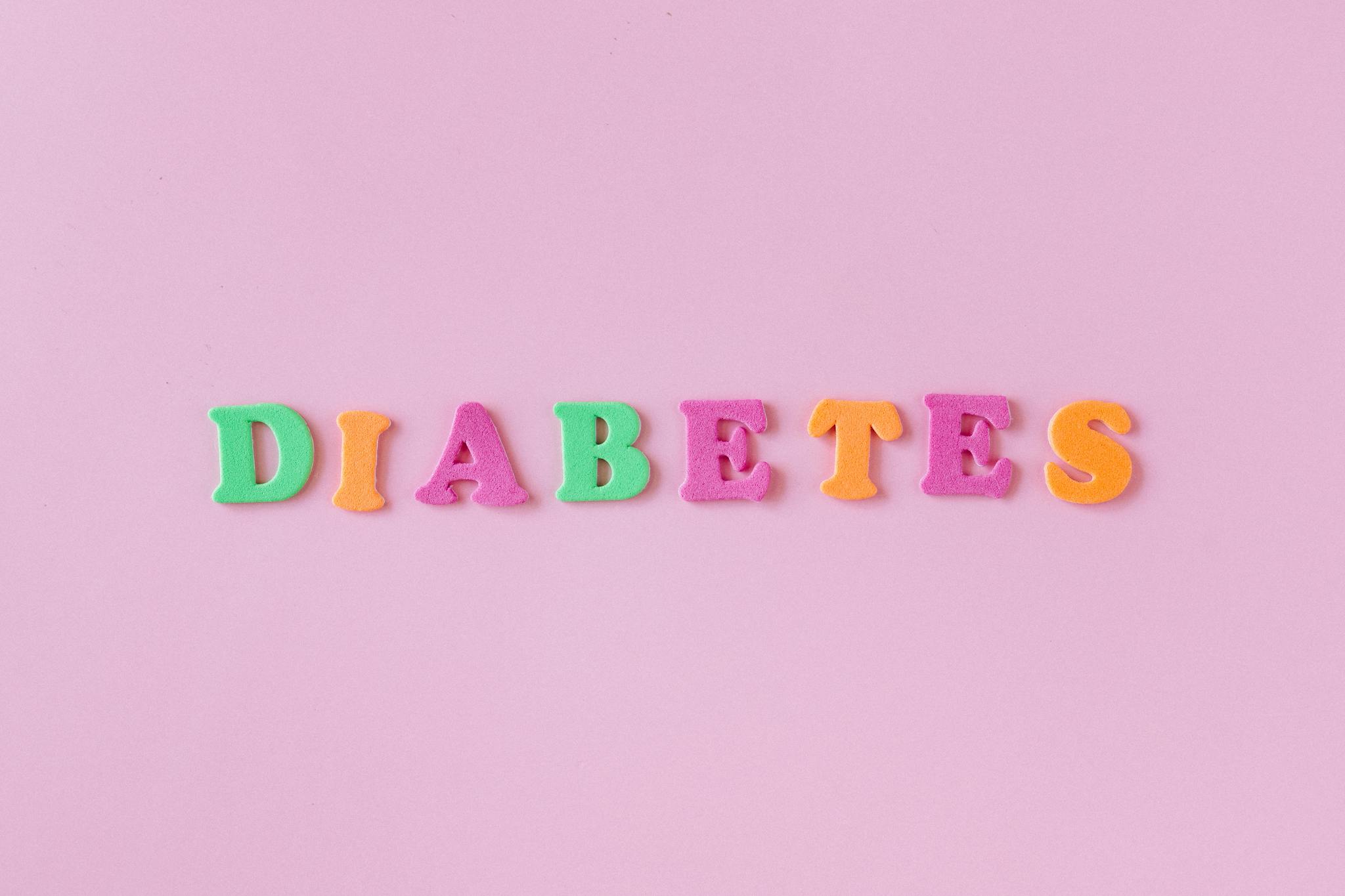 Colorful letters spelling 'diabetes' on a pink background, emphasizing health awareness.